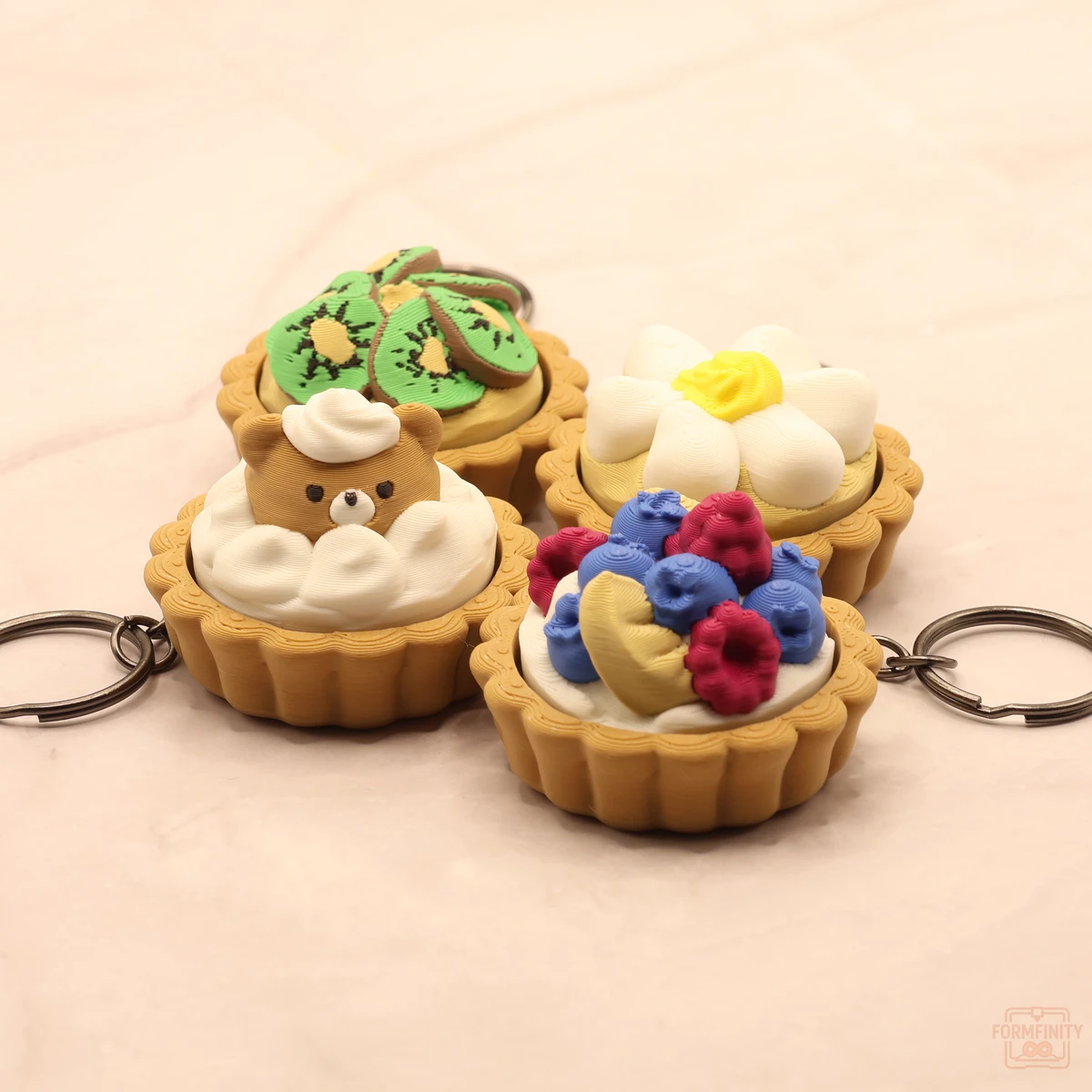 Four 3D printed dessert tart keychains - kiwi, flower custard, cream bear and mixed berry