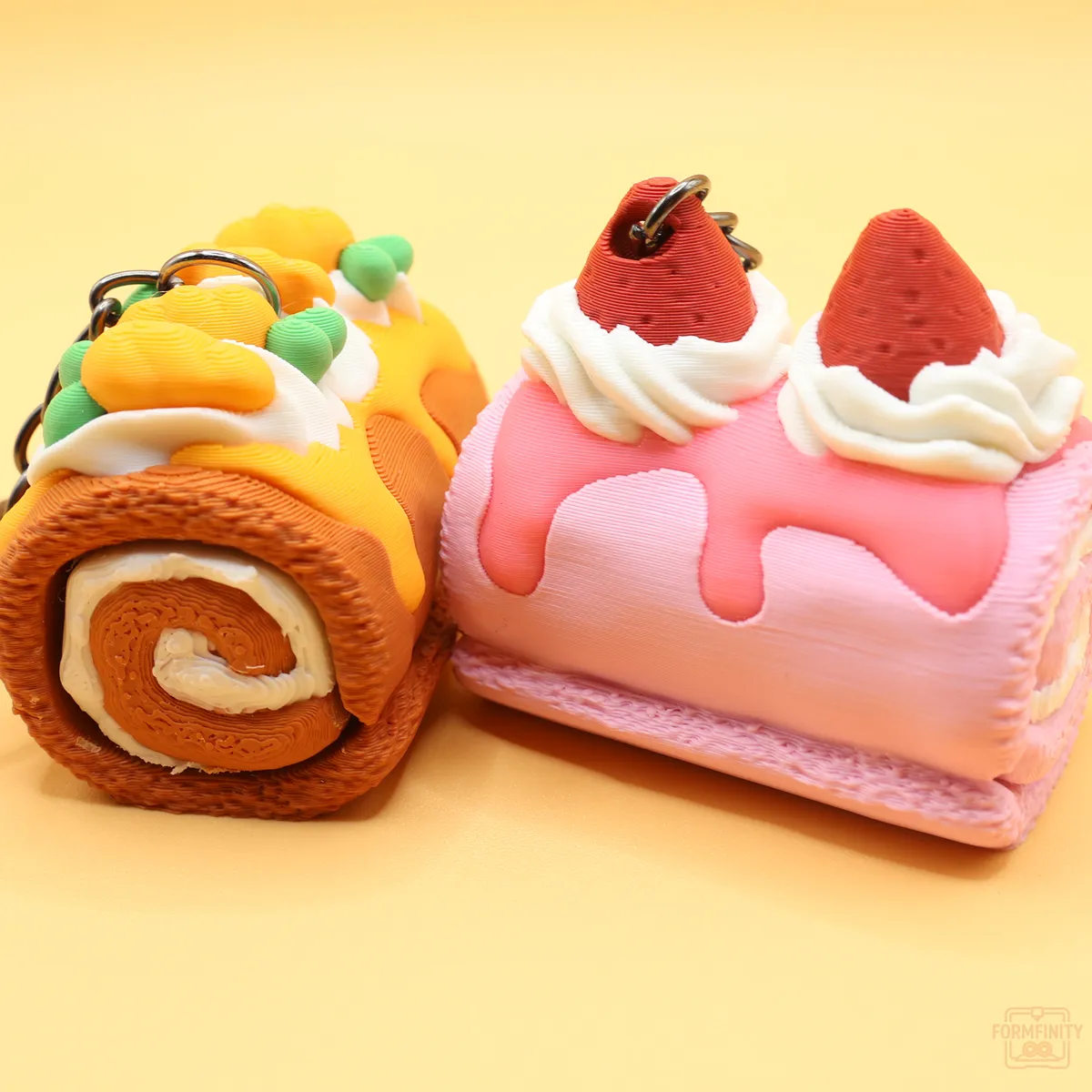 3D printed swiss roll cake fidget keychains in chocolate and strawberry