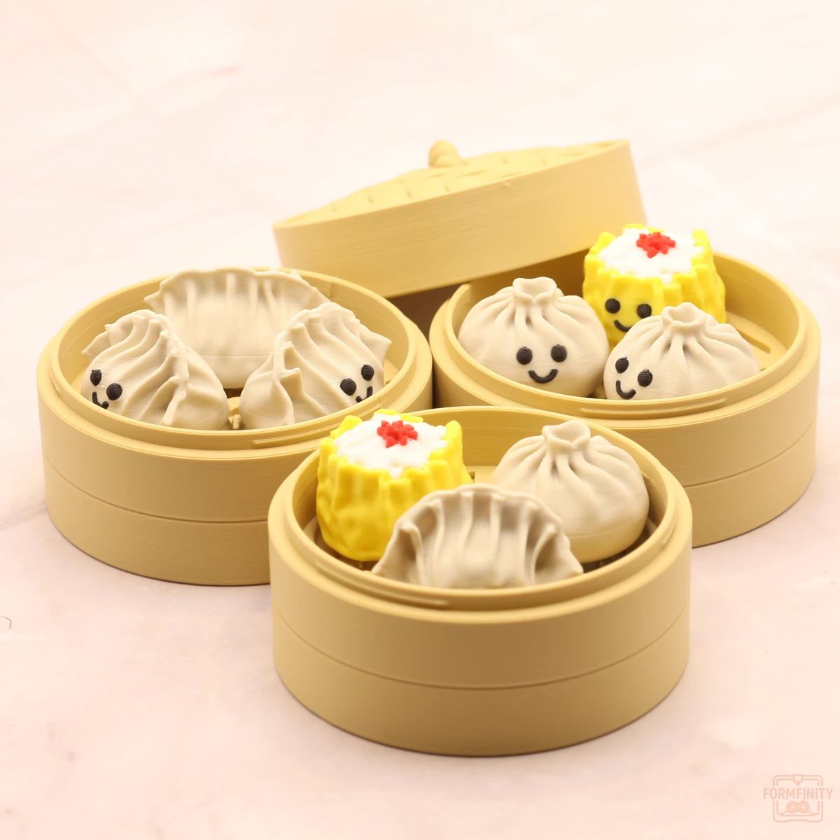 Three 3D printed steamer baskets of dim sum clickers - gyoza, bao and siu mai
