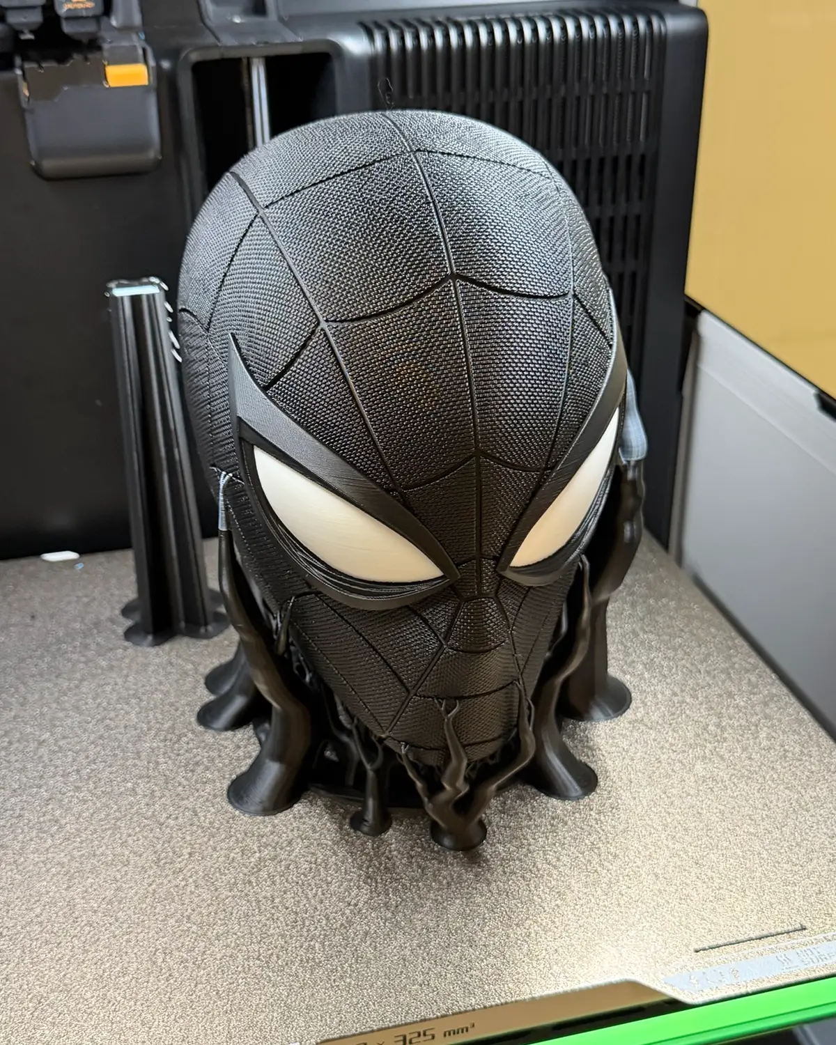 The same Spider-Man headphone stand from a slightly different angle, showing the tree supports branching up from the build plate to hold the chin and sides