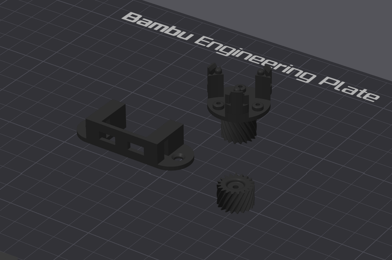 3D model preview of a mounting bracket and geared components on a Bambu Engineering Plate